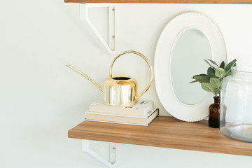 Modern Shelf Decor on Wooden Shelf, Gold Watering Can Decoration, Books, and mirror
