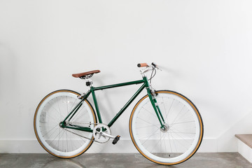 Fixed Green and Brown Bicycle in Modern Home, Fixie Bike inside hous​e, white wall background,...