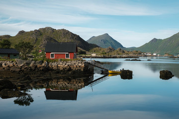 boat on the sea and red house with reflection