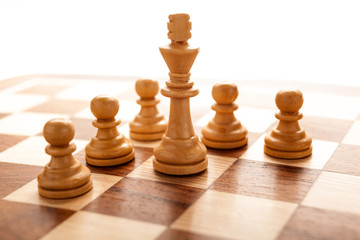 Chess piece of the white king surrounded by pawns