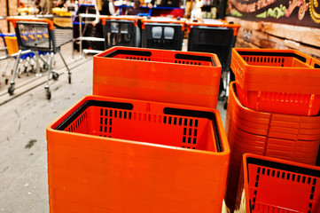Orange plastic shopping baskets on supermarket.