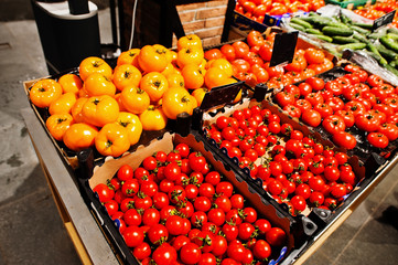 Red and yellow tomatoes vegetables on boxes at supermarket.