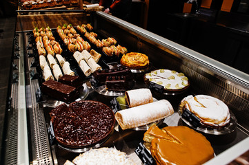 Various cakes on supermarket shelves for sale.