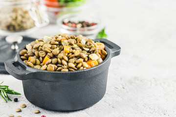 Vegetarian dish, lentils with vegetables in pot. Selective focus, space for text.