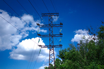 high voltage power transmission pole on background of blue sky