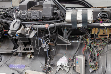 Car interior in the back of a van with a disassembled dashboard and view on shift gear and climate-control during preparation in a vehicle repair workshop. Auto service industry