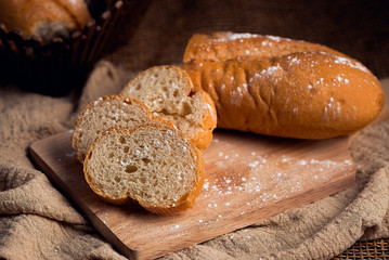 French bread, sprinkled with icing sugar on a wooden chopping board, classic colors, breakfast ideas and snacks