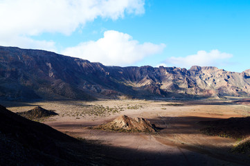 lonely mountain in the voulcanic valley inside mountains ring highlighted by the sun