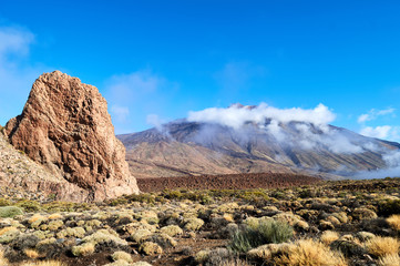 rocks and stones and mountains in the tenerife desert in yellow and orange colors and blue sky