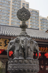 Obraz premium Elefantenbronze vor Hochäuser, Shanghai Jadebuddha Tempel