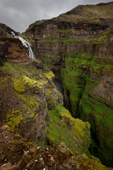 View of Glymur waterfall. Green hills, high waterfall. Iceland