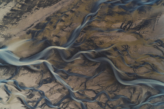 Glacial rivers seen from above, the different colors suggest the moving of different sediments at the end of the summer season. The fresh glacier water is mixing with the salt from the ocean.