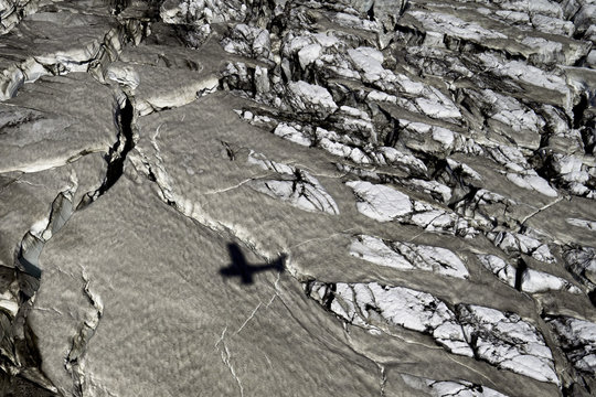 The shadow of a cessna airplane cruises over a glacier in the Icelandic highlands.