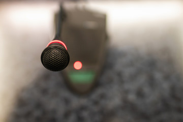 Microphone on table in meeting room with blurred business conference; selective focus.