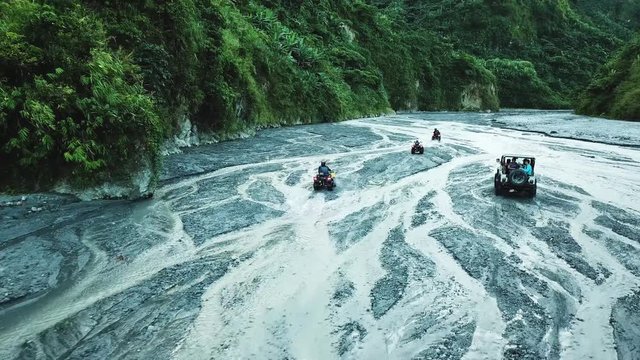 Aerial drone shot following people on an all terrain vehicle as they explore the Pinatubo volcano in the Philippines