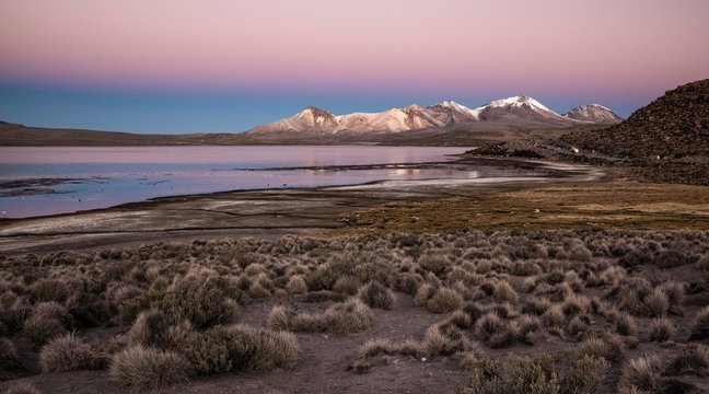 Lake Lago Chungar&middot;, red evening sky, Nevados de Quimsachata, Uqi Uqini volcano, altitude 5532m, Cerro Umurata altitude 5517m, Lauca National Park, Putre, Parinacota province, Regi&Ucirc;n de Arica y Parinacota, Chile, South America