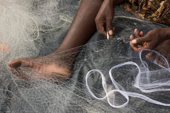 Fisherman mending a fishing net, Kerala, India, Asia