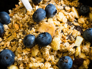 Healthy food for breakfast. Delicious tropical muesli with granola, super healthy, omega-3 and fiber rich chia seeds and fresh summer antioxidant rich blueberries Vaccinium corymbosum.