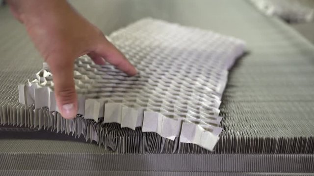 Technician making quality check on piece of honeycomb paper. Lighter furniture. Lowering costs of production. Insert of modern furniture.