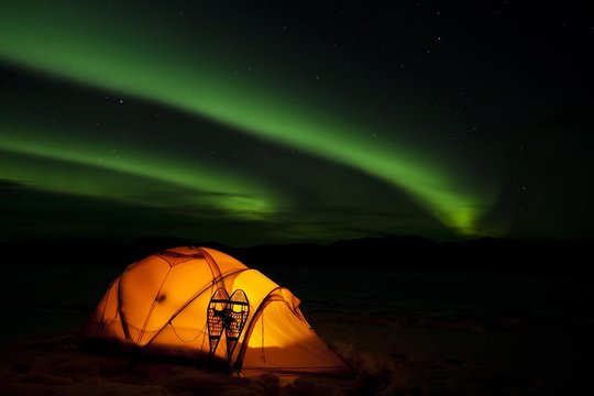 Illuminated expedition tent and traditional wooden snow shoes, Northern Lights, Polar Lights, Aurora Borealis, green, near Whitehorse, Yukon Territory, Canada, North America