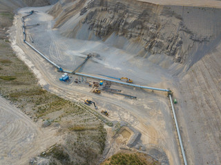 Aerial view of conveyor belt in open gravel quarry for raw material transportation