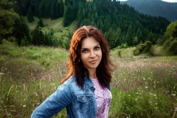 Portrait of a beautiful girl on the background of the beautiful Carpathian mountains. Travel concept, leisure activity, vacation