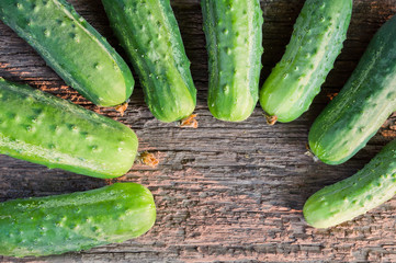 Fresh organic cucumbers on the old wooden background