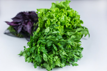 Reusable eco friendly black bag with organic fresh greenery (lettuce leaves, spinach, parsley, dill, basil) on light grey table, from market. Zero waste grocery shopping concept. Close up