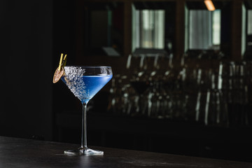 Aviation, drink with gin, lemon juice,maraschino liqueur and violette cream liquor. Garnished with lime chips and coconut crumbles. Place for text copy-paste. Cocktail on a black background