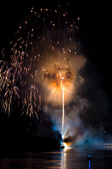 Colorful fireworks. Fireworks are a class of explosive pyrotechnic devices used for aesthetic and entertainment purposes. Visible noise due to low light, soft focus, shallow DOF, slight motion blur