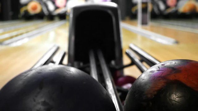 Bowling Ball out of Ball Return. Media. Ball was rolled out, varicolored bowling balls lie in bowling club