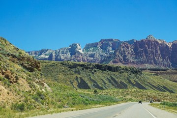 Fototapeta premium driving by green hills and cliffs