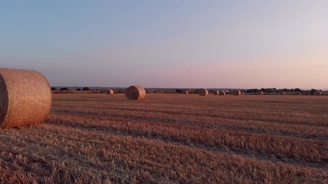 Flight at sunrise between bales in a wheat field, Sicily, Italy, 4K