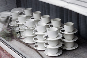 pattern of pairs of mugs and plates with spoons in the window of the tableware store