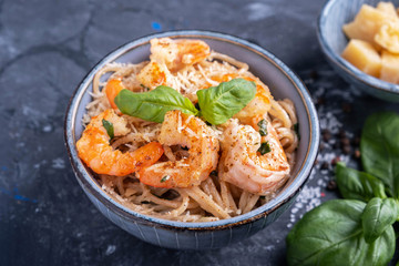Pasta with shrimps in a plate, close-up. Pasta cooking concept, ingredients and spices on a table with a dish.