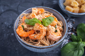 Pasta with shrimps in a plate, close-up. Pasta cooking concept, ingredients and spices on a table with a dish.