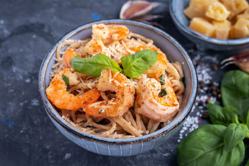 Pasta with shrimps in a plate, close-up, copy space, top view. Pasta cooking concept, ingredients and spices on a table with a dish.