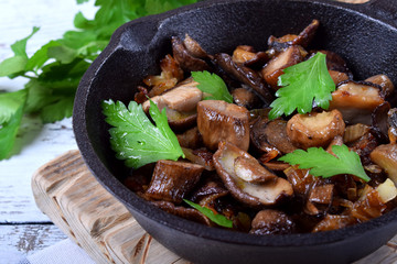 Roasted forest mushrooms topped with fresh parsley in a cast iron pan