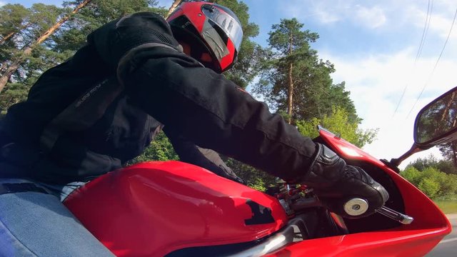 A person in a helmet is riding a red motorbike