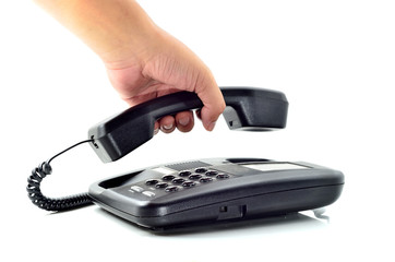 Male hand holding phone receiver over telephone