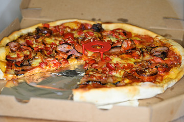 Sausage pizza with hot peppers in detail.