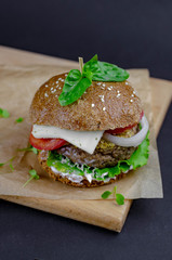 burger with homemade whole grain bun, beef cutlet, tomatoes, onion, salad, mozzarella, yogurt and mustard. healthy food. proper nutrition fast food