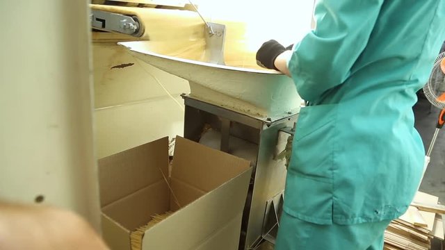 Packing pasta at the factory. Line for packaging pasta in plastic bags. Worker packs spaghetti in cardboard boxes. Large cardboard boxes with spaghetti. Packing workshop at a pasta factory.