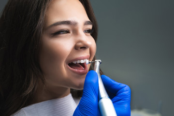 process of applying dental brush as a stage of professional dental cleaning procedure in clinic close up