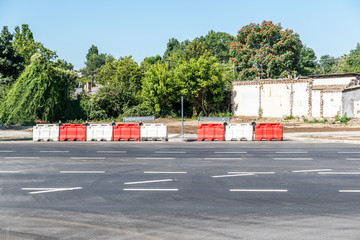 White and red plastic road safety barriers on the new highway street reconstruction and construction site in the city as warning for drivers that one direction is closed