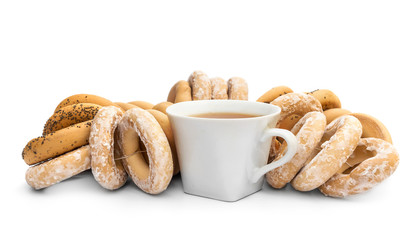 Cup of tea and bunch of drying bagels on white.