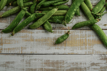 fresh whole peas on a wooden table