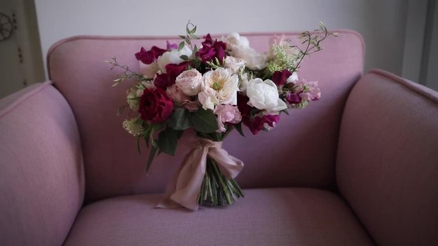An elegant bridal bouquet from fresh flowers of roses and peonies, white, burgundy and pink shades. Details luxury wedding. Florist shop.