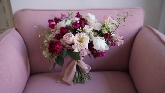An elegant bridal bouquet from fresh flowers of roses and peonies, white, burgundy and pink shades. Details luxury wedding. Florist shop.