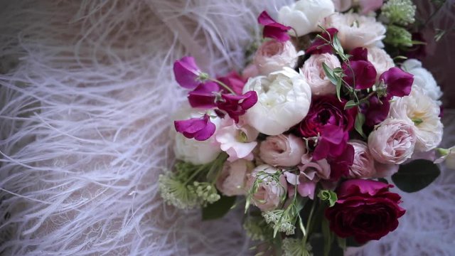 An elegant bridal bouquet from fresh flowers of roses and peonies, white, burgundy and pink shades. Details luxury wedding. Florist shop.